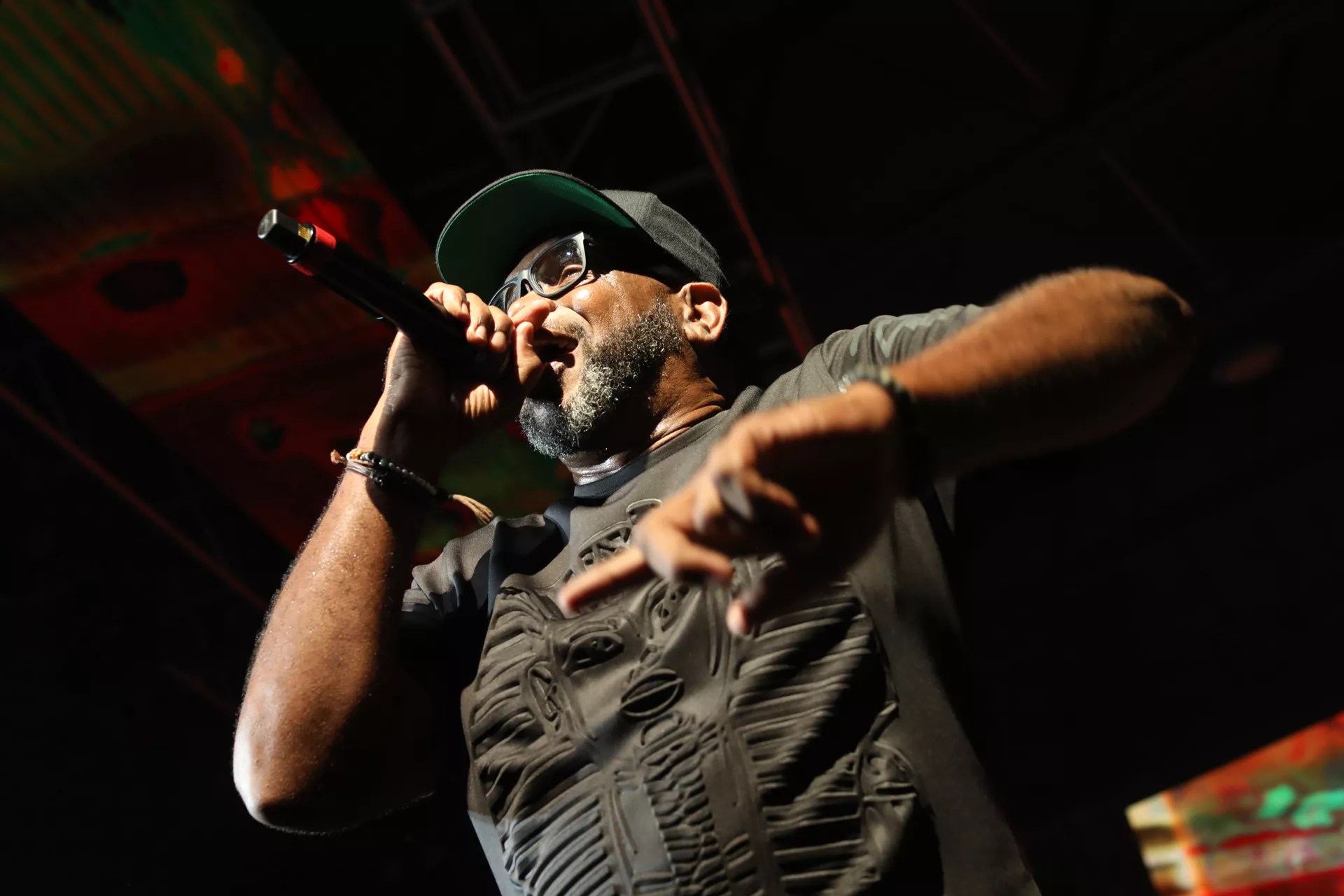 Photo pf a man holding a mic on stage.