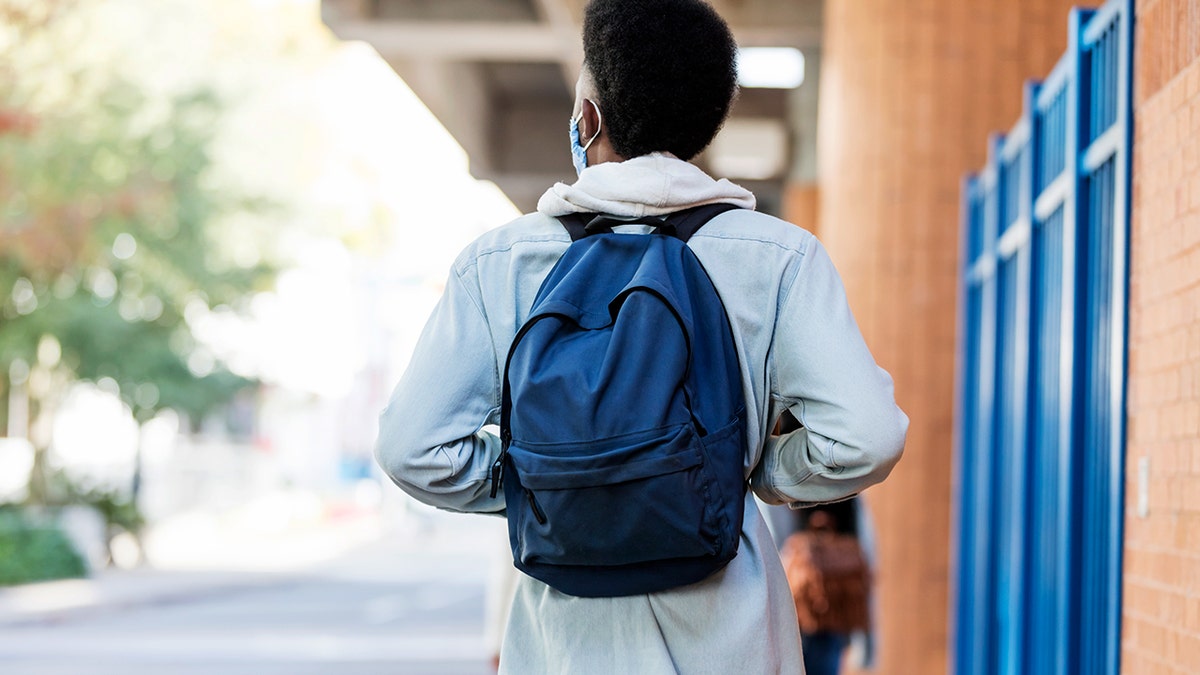 COllege student from behind wearing a medical mask