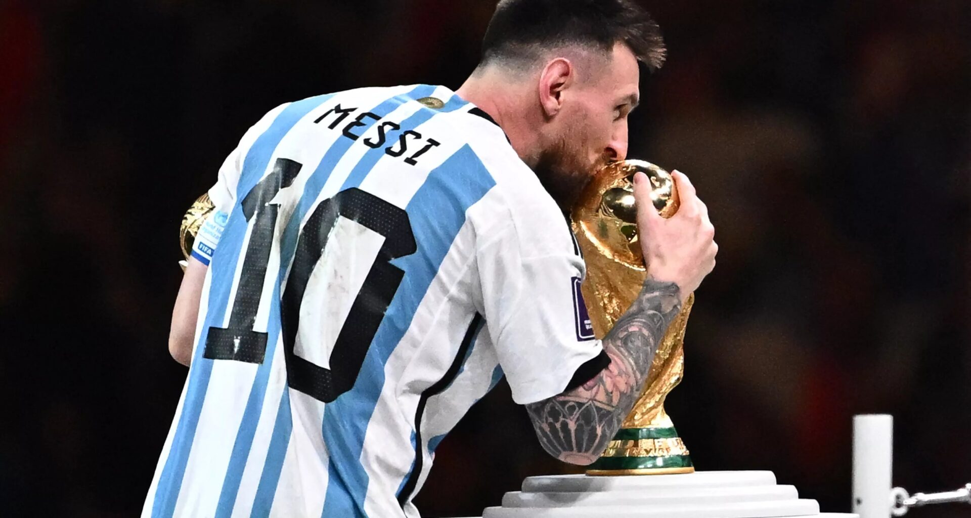 Soccer legend Lionel Messi kisses the World Cup trophy.