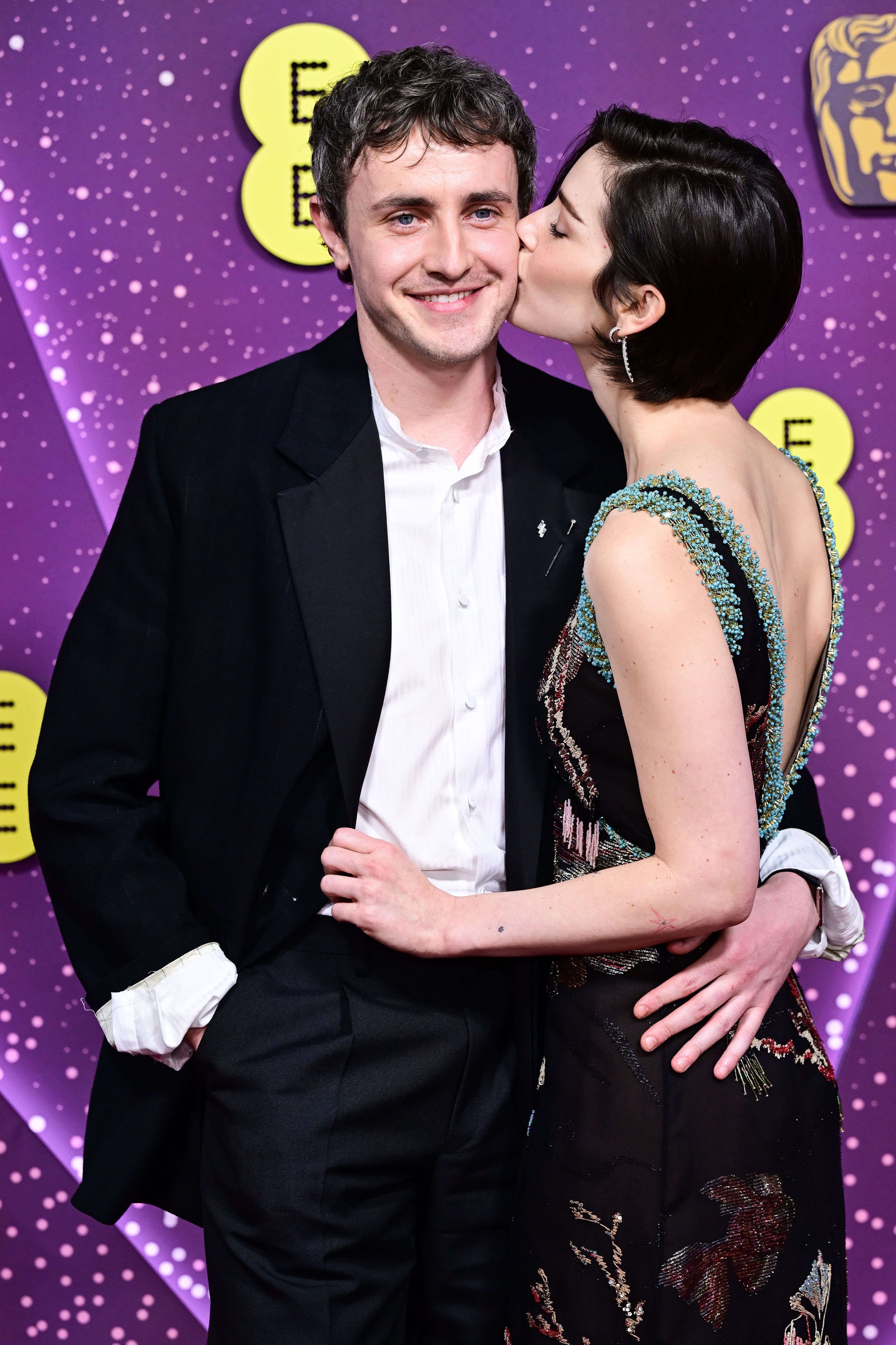 Gracie Abrams puckers up to boyfriend Paul Mescal while attending the 79th BAFTA British Academy Film Awards in London.