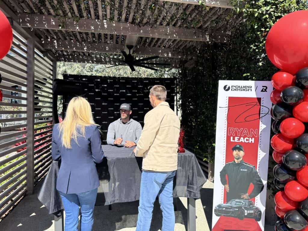 A race driver signing autographs