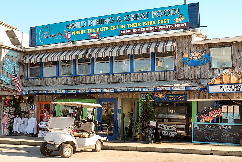 Shops and restaurants are open for business along the Gulf of Mexico waterfront in Cedar Key, Florida. Image credit: Leigh Trail via Shutterstock.