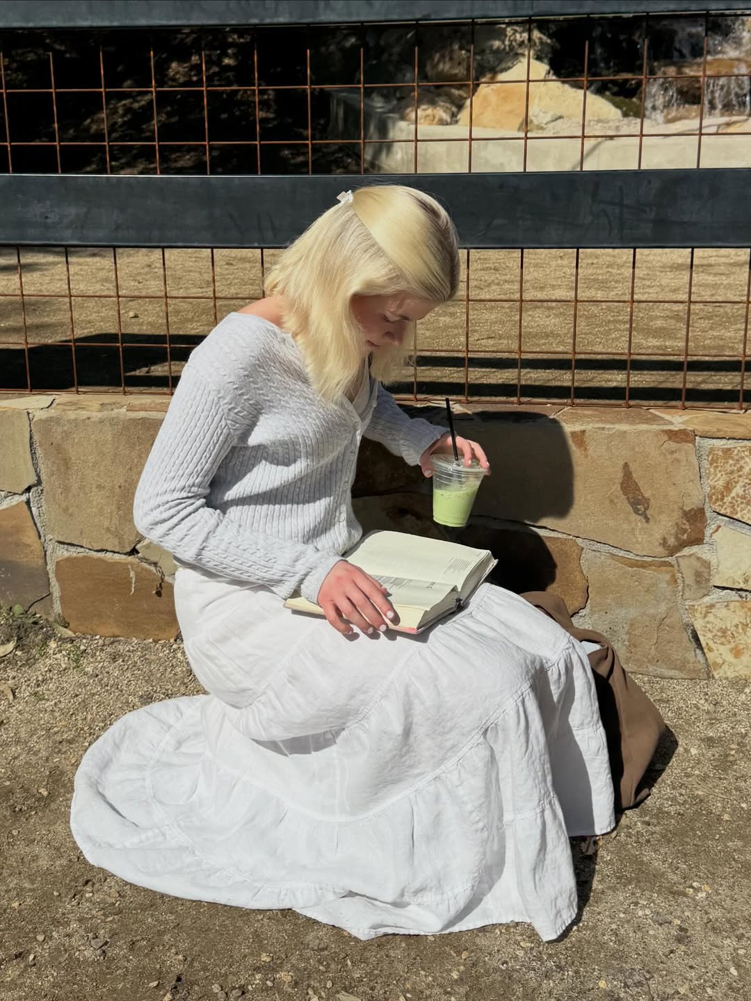 Lola Sheen soaks up some sun with her matcha and a book.