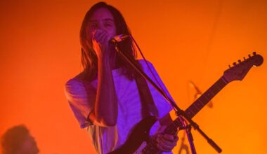 A man singing on stage under orange lights