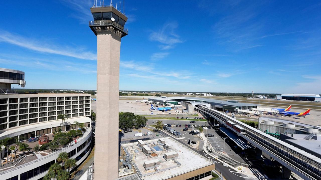 Airplanes are parked at gates near the air traffic control tower at the Tampa International Airport, Nov. 11, 2025, in Tampa, Fla. (AP Photo/Chris O'Meara)