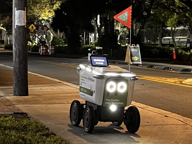 An Uber Eats branded food delivery robot makes its way down the sidewalk on Northeast First Street in downtown Fort Lauderdale, Dec. 27, 2025. (Gretchen Day-Bryant/South Florida Sun Sentinel)