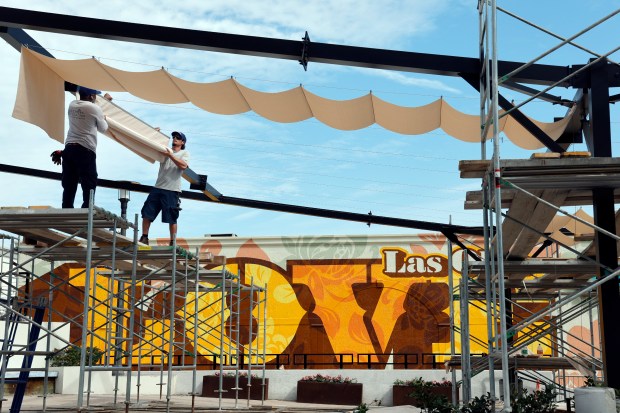 Workers install shade coverings at Tunnel Top Plaza on Las Olas Boulevard in Fort Lauderdale on Wednesday. (Amy Beth Bennett/South Florida Sun Sentinel)
