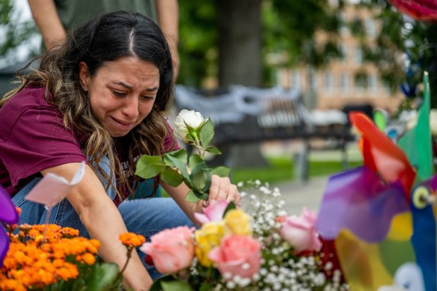 Angeli Rose Gomez, a mother who rushed into Robb Elementary School to save her two children, places roses down at a memorial dedicated to the 19 children and two adults murdered on May 24, 2022 during the mass shooting at Robb Elementary School on May 25, 2023 in Uvalde, Texas. Today marks the 1-year anniversary of the mass shooting at Robb Elementary School. 19 children and two teachers were killed when a gunman entered the school, opening fire on students and faculty. (Brandon Bell/Getty Images)