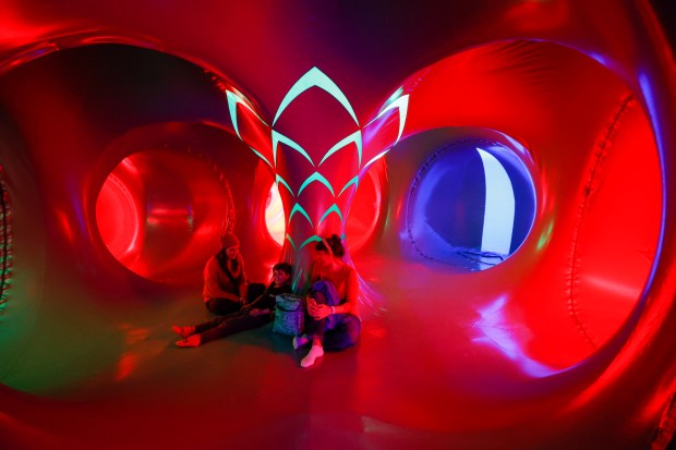 Sabrina, Allison, and Cassius Guimaraes explore the Architects of Air Arborialis walk-through experience at the Seneff Arts Plaza at the Dr. Phillips Center for the Performing Arts on Friday, 2026. The large, cavernous 17,000-square-foot inflatable structure of fabric and air creates a colorful labyrinth connected by domes and vibrant walkways. It is filled with ephemeral music for an otherworldly experience that guests can explore as part of Immerse 2026. (Rich Pope/Orlando Sentinel)