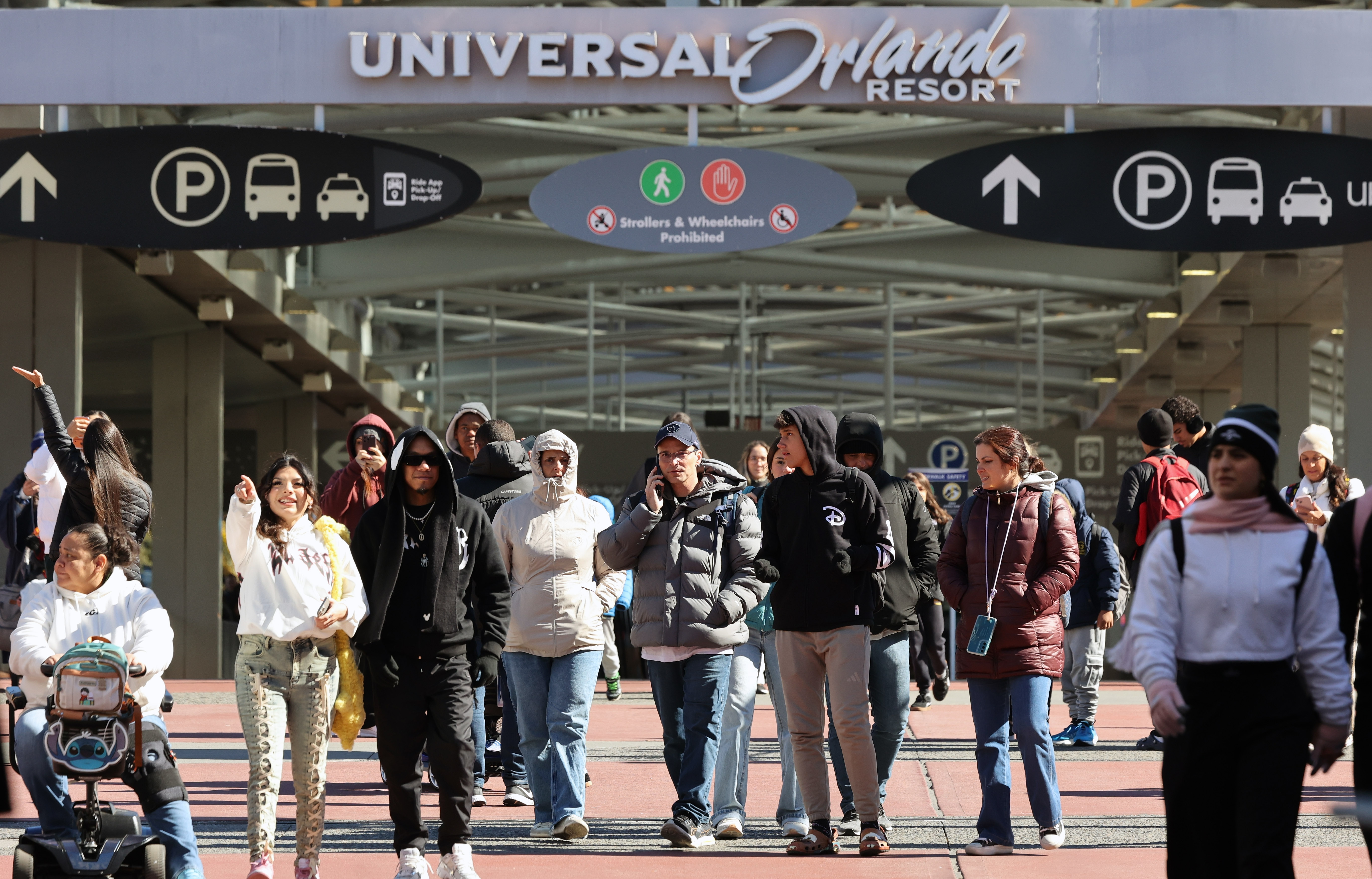 Parkgoers are bundled up as they enter Universal CityWalk Orlando...
