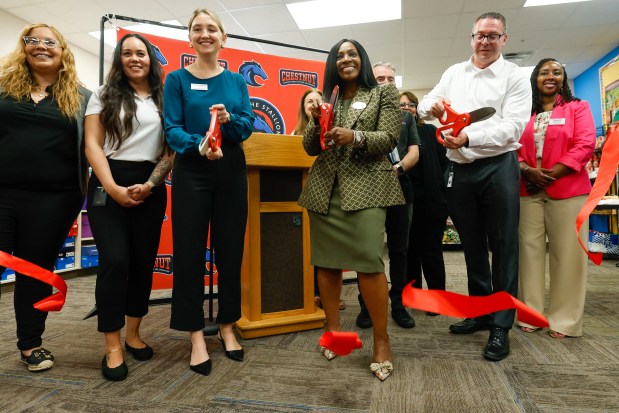 From center left to right, Briana Rebello, schools partnership manager with Second Harvest Food Bank of Central Florida; Mia Poinsette, director of the Poinsette Foundation; and Gary Bressler, Chestnut Elementary School principal, cut the ribbon at the school's food pantry on Friday, February 27, 2026. The pantry is the result of Second Harvest Food Bank of Central Florida's $75,000 donation, which will go toward its school program aimed at reducing food insecurity. (Rich Pope/Orlando Sentinel)