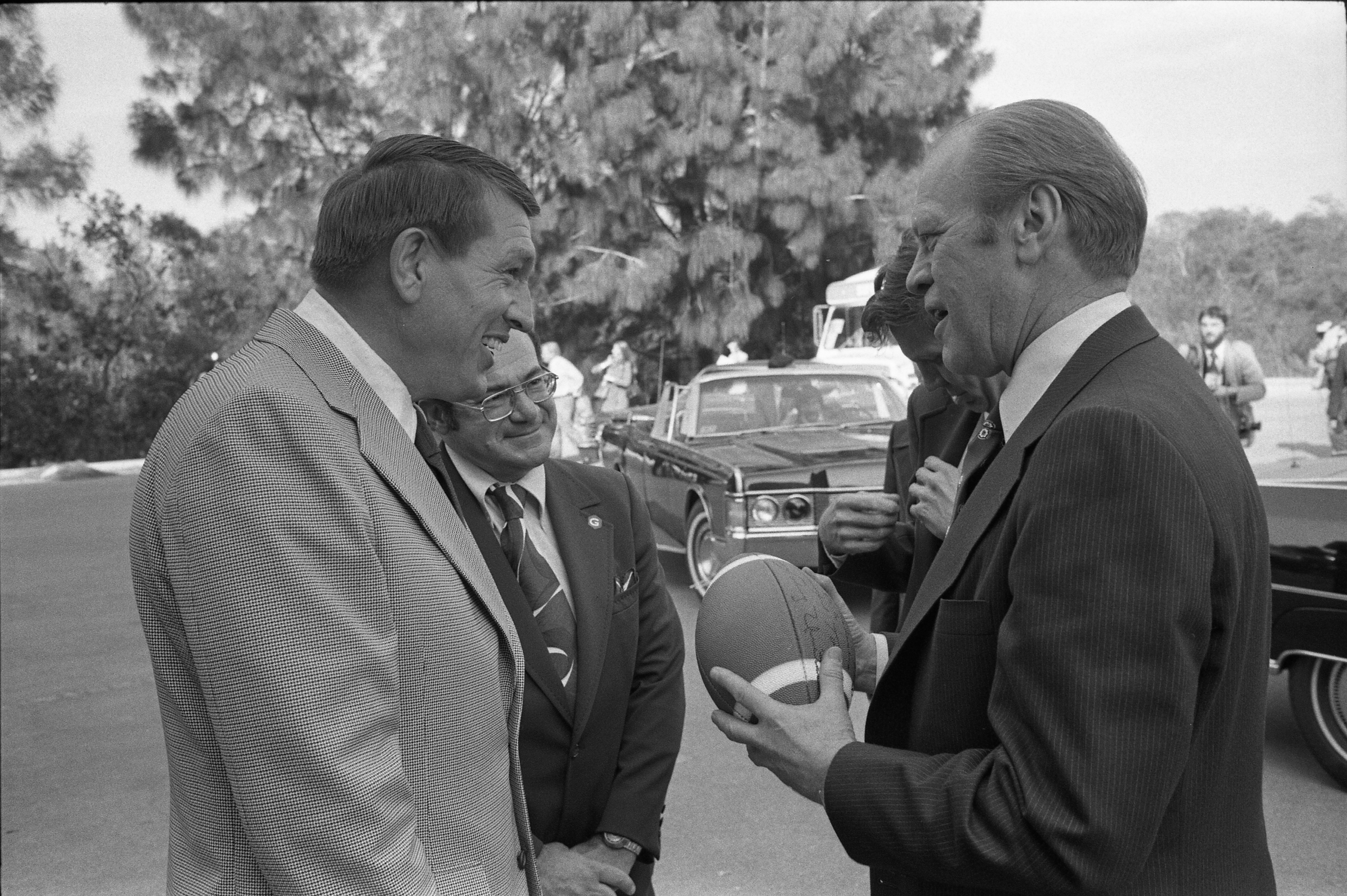 Former Baltimore Colts quarterback Johnny Unitas presents a signed football...