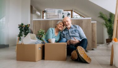 Older couple, resting in the middle of moving boxes.