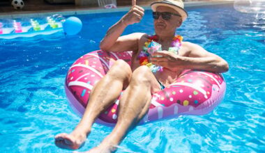 An older person in a floatation device in a swimming pool.