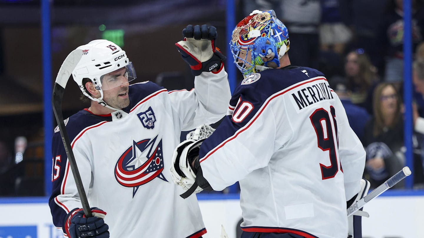 Blue Jackets defenseman Dante Fabbro celebrates an empty net goal with goaltender Elvis Merzlikins, who picked up the assist.