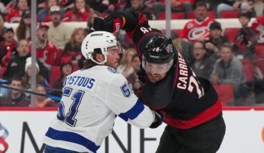 Feb 26, 2026; Raleigh, North Carolina, USA;  Carolina Hurricanes left wing William Carrier (28) and Tampa Bay Lightning defenseman Charle-Edouard D'Astous (51) battle during the third period at Lenovo Center. Mandatory Credit: James Guillory-Imagn Images