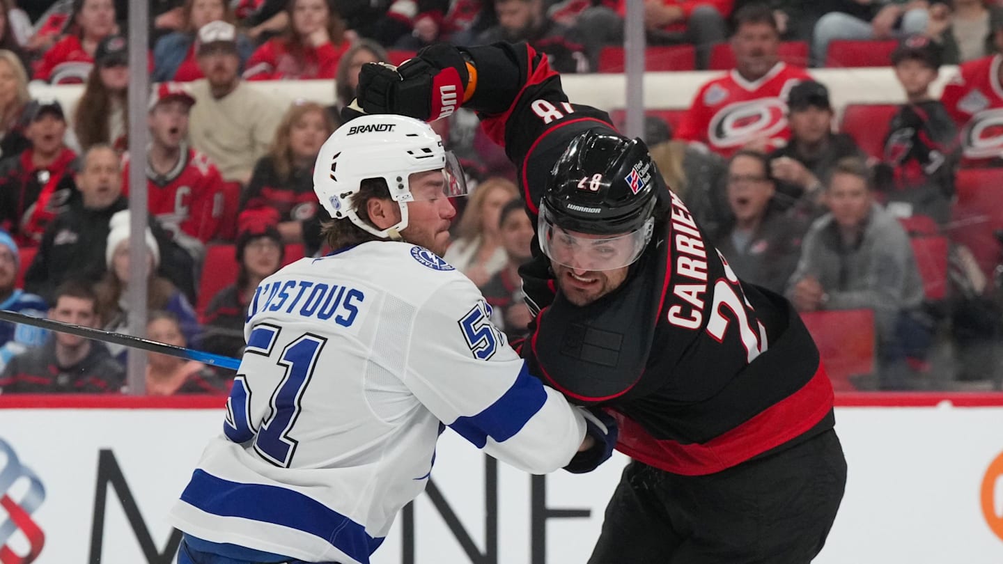 Feb 26, 2026; Raleigh, North Carolina, USA;  Carolina Hurricanes left wing William Carrier (28) and Tampa Bay Lightning defenseman Charle-Edouard D'Astous (51) battle during the third period at Lenovo Center. Mandatory Credit: James Guillory-Imagn Images