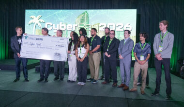 University of South Florida students and the university president accept an oversized check from Peter Bellini of connect secure.