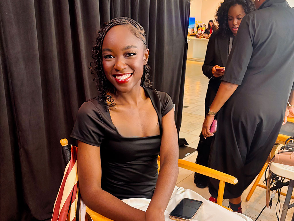 Dupe Oloyede smiling after having her makeup done pre-show. 