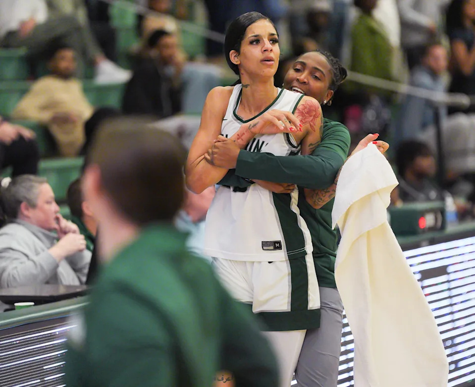 Jacksonville University guard Priscilla Williams (23) is pulled away from a fight in the fourth period by JU assist. coach Shenneika Smith. [Doug Engle/Florida Times-Union]