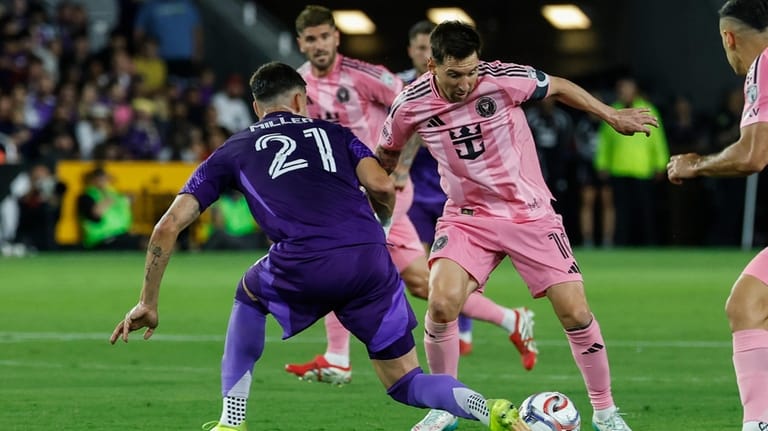 Inter Miami CF forward Lionel Messi, right, controls the ball...