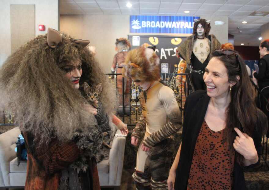 Abigail Aldridge nuzzles Cape Coral Animal Shelter namesake Grizabella as Director/Choreographer Amy McCleary looks on.