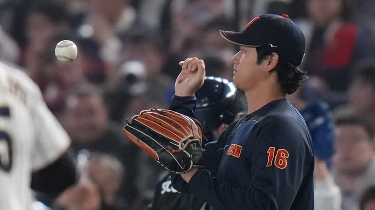 Japan's Shohei Ohtani catches a ball as he warms up...
