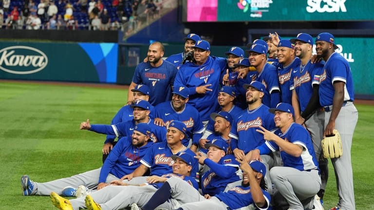 The Venezuela team poses for photos on the field before...