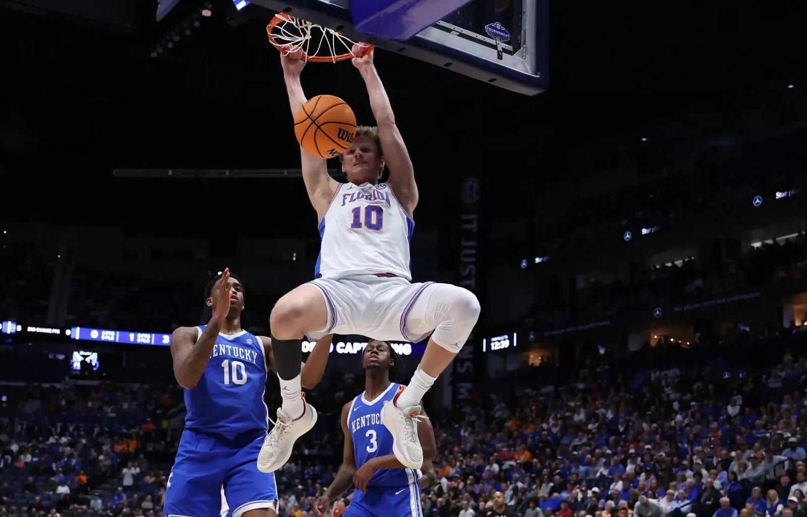 Thomas Haugh and Rueben Chinyelu talk on the sideline with associate head coach Carlin Hartman.