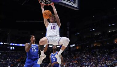 Thomas Haugh and Rueben Chinyelu talk on the sideline with associate head coach Carlin Hartman.