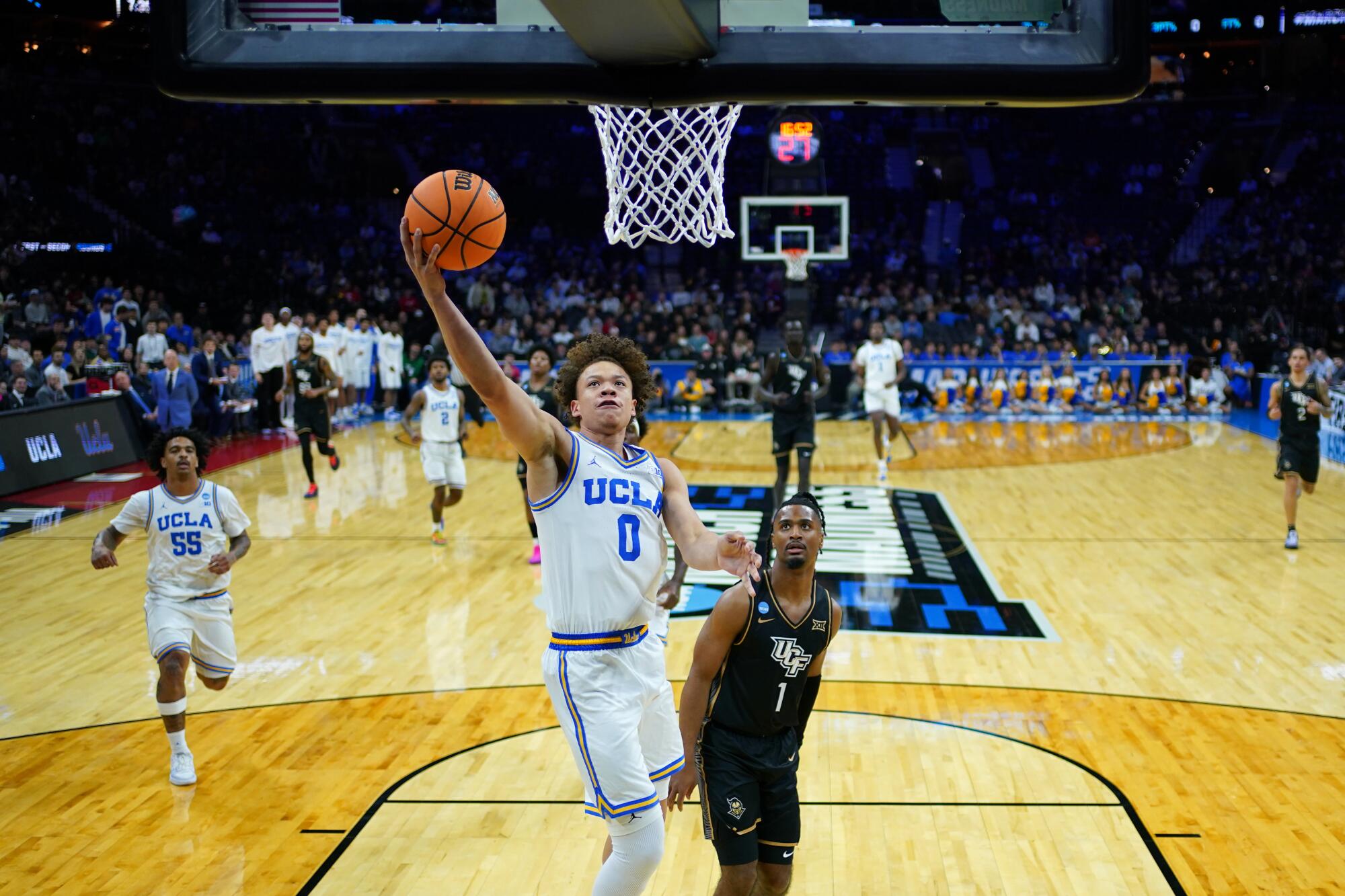 UCLA's Trent Perry, left, shoots over Central Florida's Themus Fulks during the first half Friday.