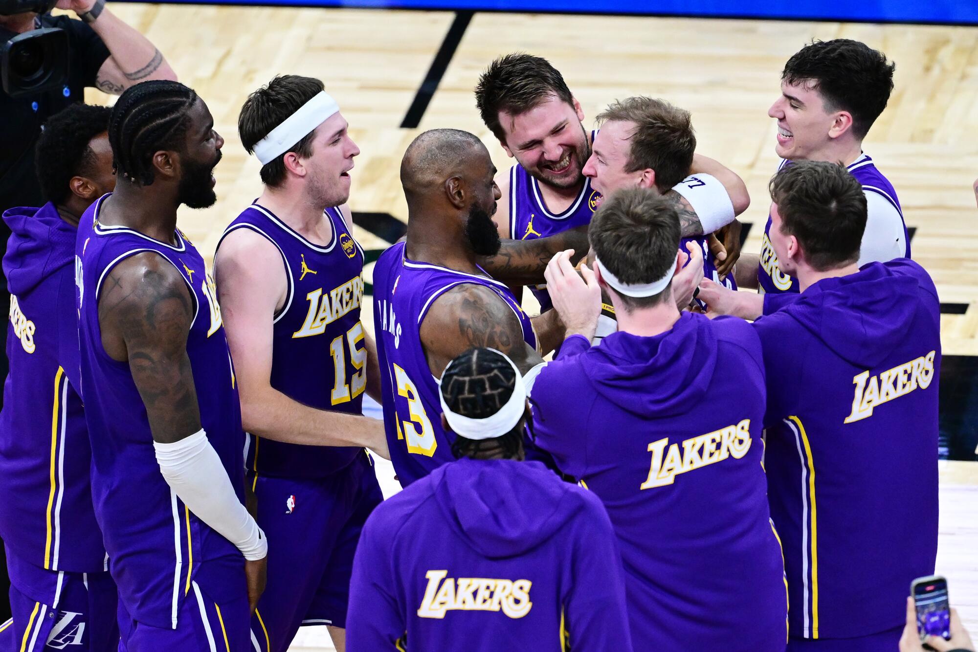 Lakers guard Luke Kennard celebrates with teammates after his game-clinching three-pointer Saturday against Orlando.