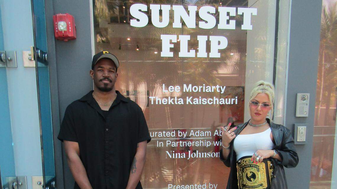 Two wrestlers discuss their artwork at their exhibit in Miami