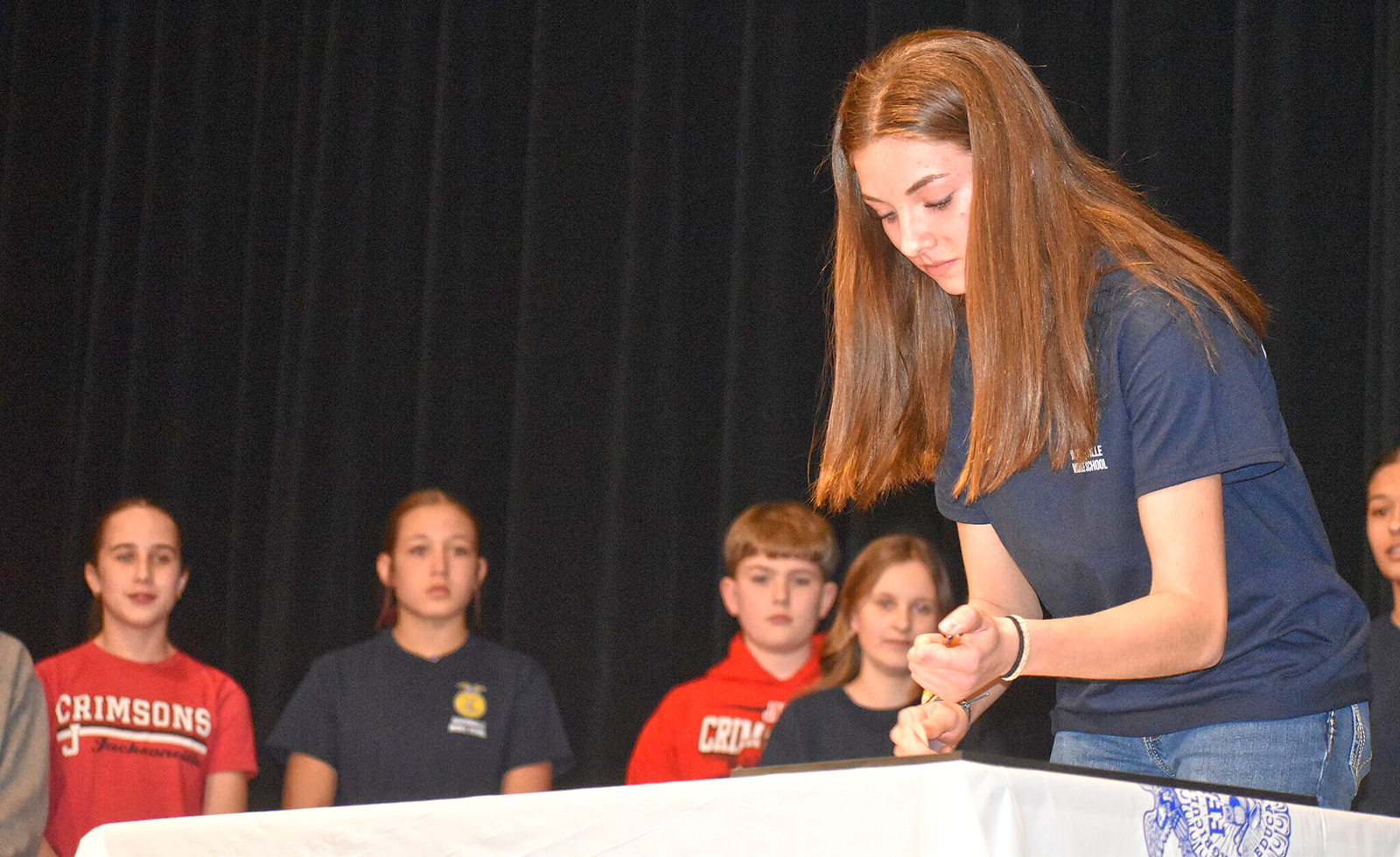 Jacksonville Middle School eighth-grader Marley Schlieker signs a charter establishing the school's FFA chapter. 