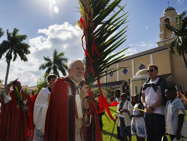 Archbishop Thomas Wenski, center, processes past the crowd towards the cathedral after the traditional blessing of the palms before Palm Sunday Mass on Sunday, March 29, 2026, at the Cathedral of St. Mary in Miami, Fla. “It is easy for us to say we would’ve done something different than the crowd or Pontius Pilate, but when we are silent in the face of suffering in the world around us [we are complacent],” said the Archbishop in his homily at mass.