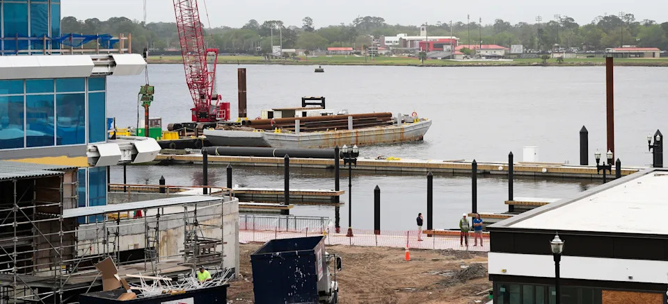 Construction continues March 25 on the rebuilt Metropolitan Park Marina. that will be near the Four Seasons Hotel and  Residences Jacksonville, a part of which is shown to the left, and the Asado Life restaurant at right.