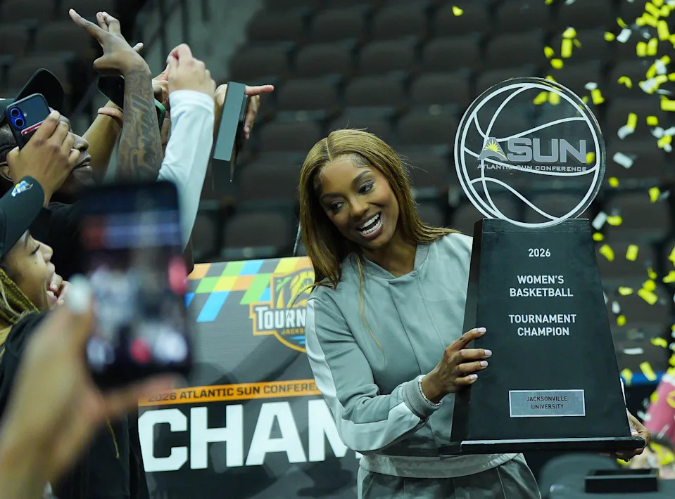Jacksonville University head coach Special Jennings celebrates with the trophy after Jacksonville University defeated Austin Peay 66-63 in overtime in the ASUN Women's Basketball Tournament Championship at VyStar Veterans Memorial Arena Monday, March 9, 2026 in Jacksonville, Fla. [Doug Engle/Florida Times-Union]