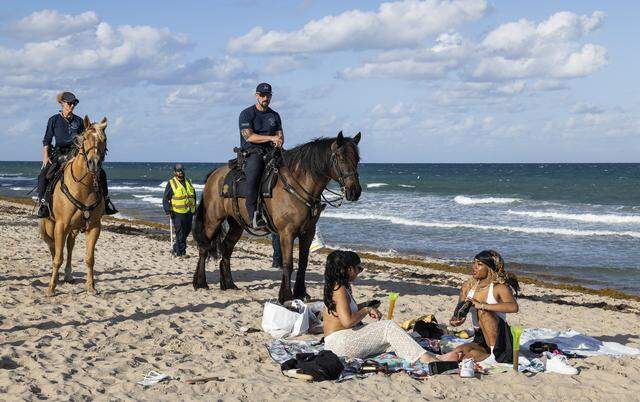 Police officers ask people to leave a section of Las Olas Beach for cleaning during spring break on Friday, March 20, 2026, in Fort Lauderdale, Fla.