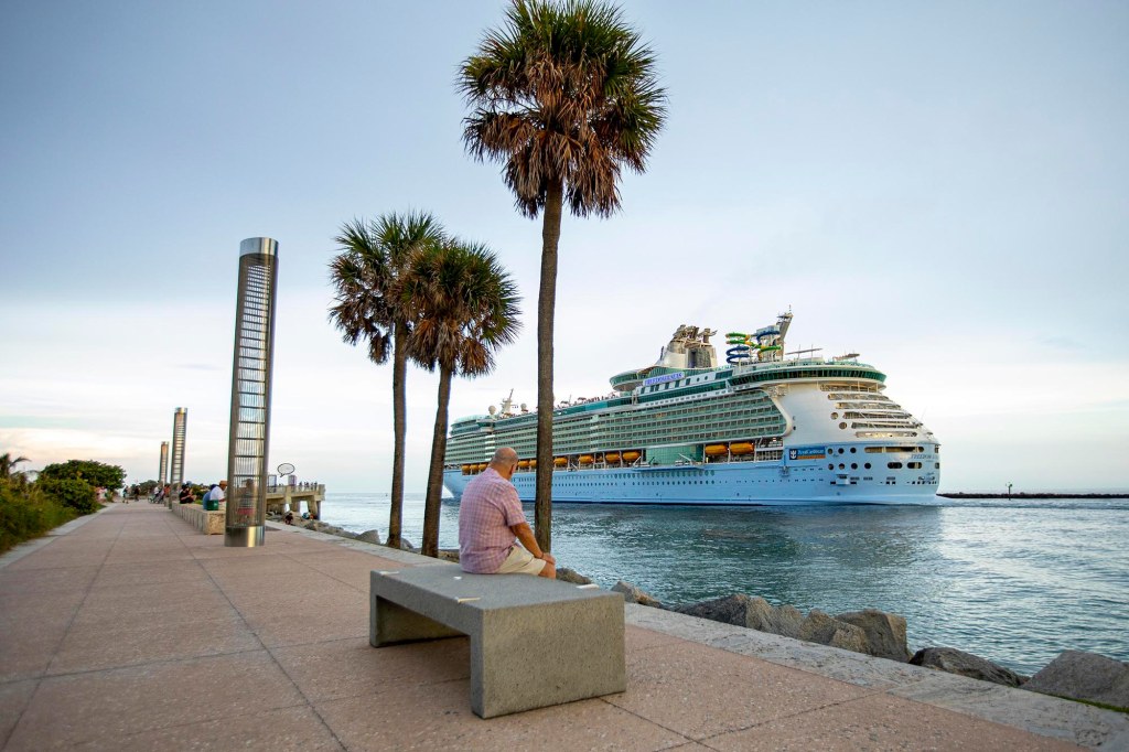 Man watching the Royal Caribbean International's Freedom of the Seas cruise ship depart from PortMiami.
