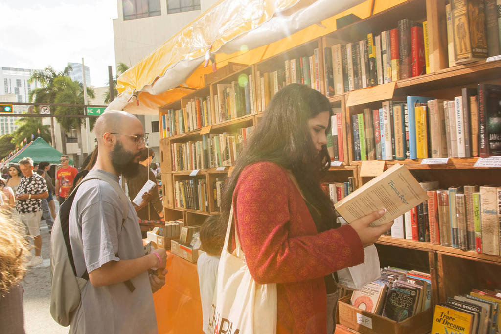 Miami Book Fair attendees in front of a shelf of books
