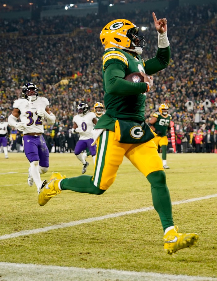 Malik Willis runs for a touchdown and points his finger in the air