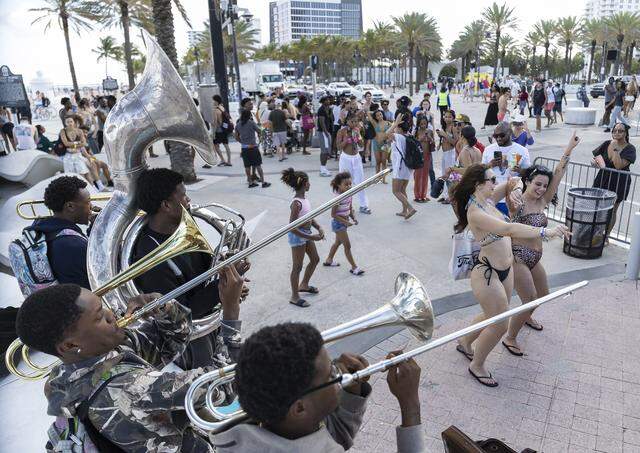A1 Brass performs as people make their way down Fort Lauderdale Beach Boulevard during spring break at Las Olas Beach on Friday, March 20, 2026, in Fort Lauderdale, Fla.