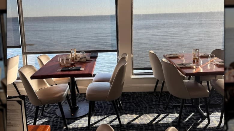 Tables set for dinner in front of large view windows at Rusty Pelican, Tampa