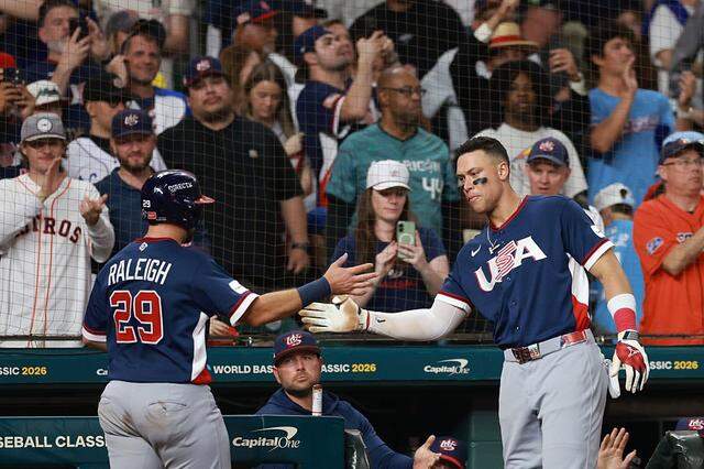 HOUSTON, TEXAS - MARCH 13: Cal Raleigh #29 celebrates his score with Aaron Judge #99 of Team United States during the sixth inning against Team Canada at Daikin Park on March 13, 2026 in Houston, Texas. (Photo by Kenneth Richmond/Getty Images)