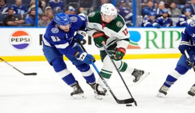 Tampa Bay Lightning defenseman Erik Cernak (81) and Minnesota Wild left wing Matt Boldy (12) battle for a loose puck during the first period of an NHL hockey game Tuesday, March 24, 2026, in Tampa, Fla. (AP Photo/Chris O'Meara)