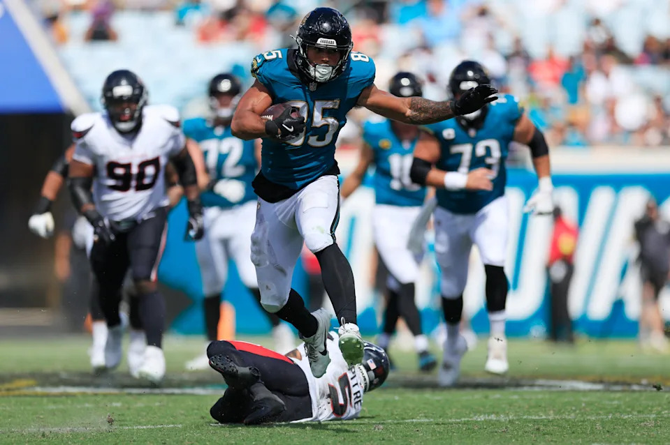 Jacksonville Jaguars tight end Brenton Strange (85) rushes for yards leapng past Houston Texans safety Jalen Pitre (5) during the third quarter of an NFL football matchup at EverBank Stadium, Sunday, Sept. 21, 2025, in Jacksonville, Fla. The Jaguars defeated the Texans 17-10.
