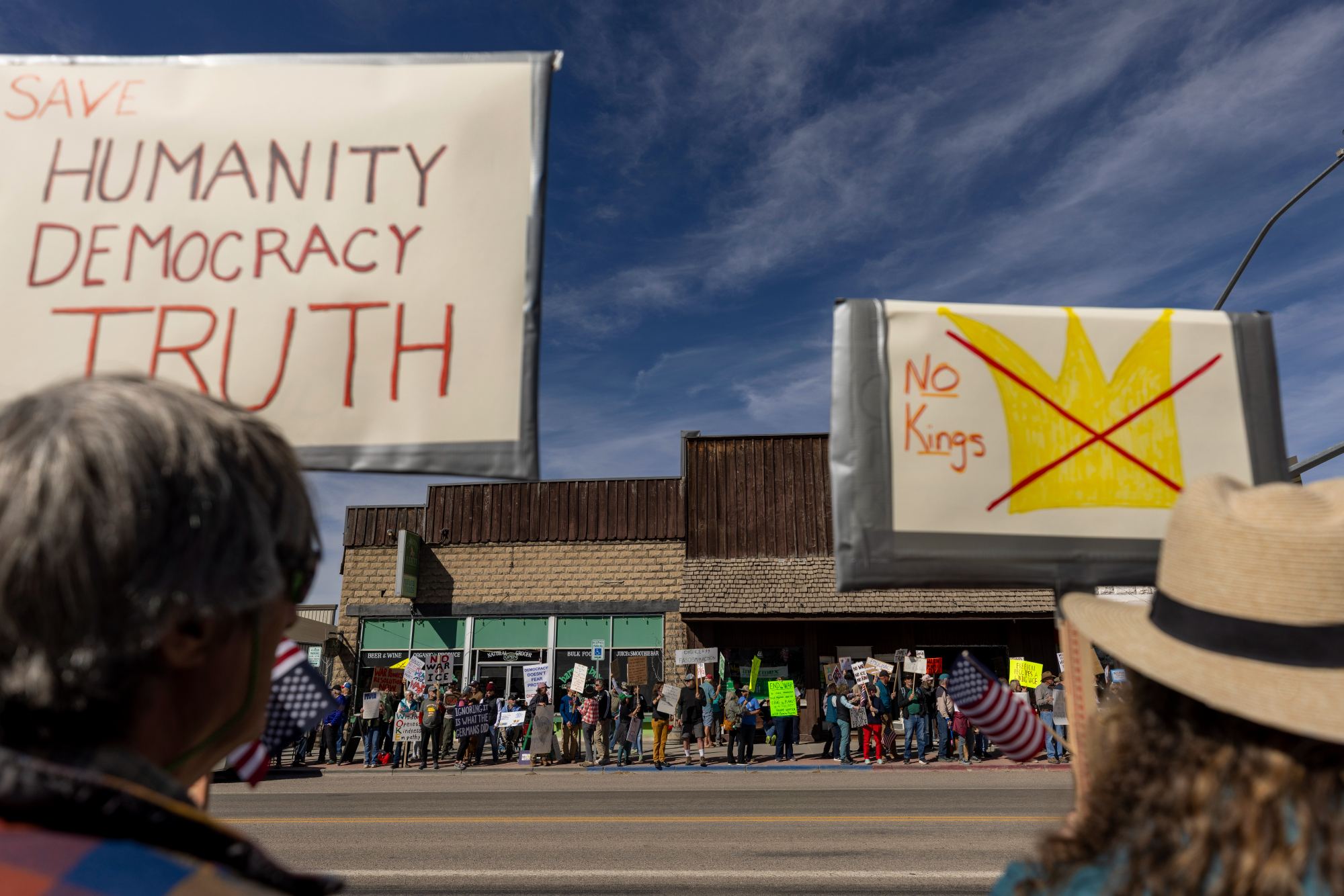 A sign reads: SAVE HUMANITY DEMOCRACY TRUTH.