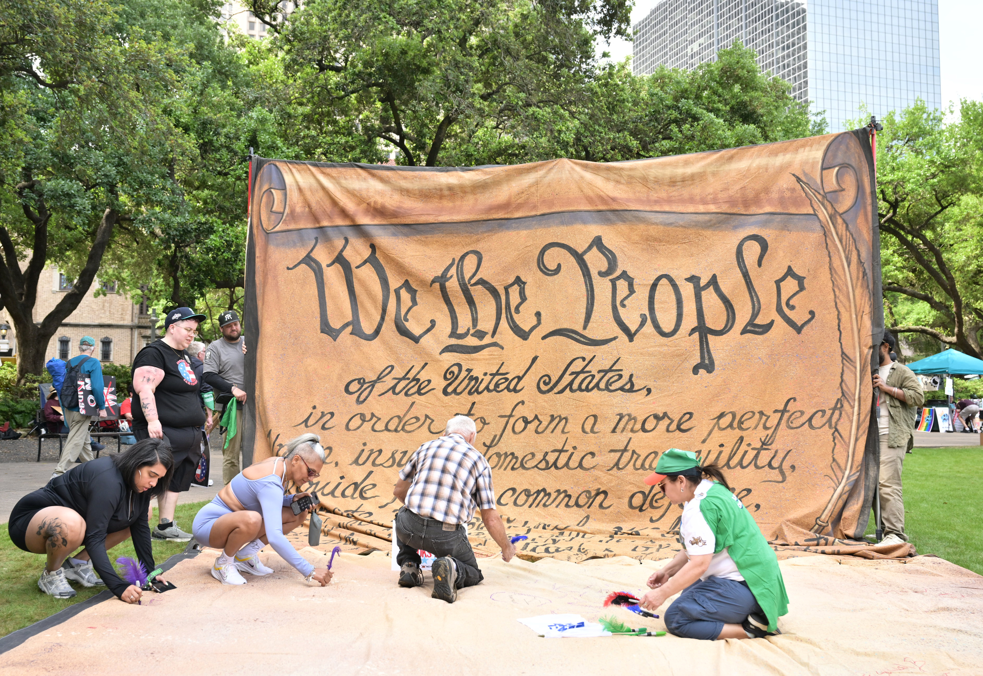 People sign onto a giant We The People banner. 