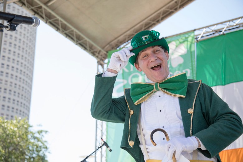 Entertainer dressed as a leprechaun celebrating St. Patrick's Day at an outdoor festival event in downtown Tampa.