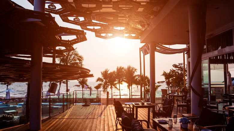 A restaurant patio along a waterfront as the sun sets